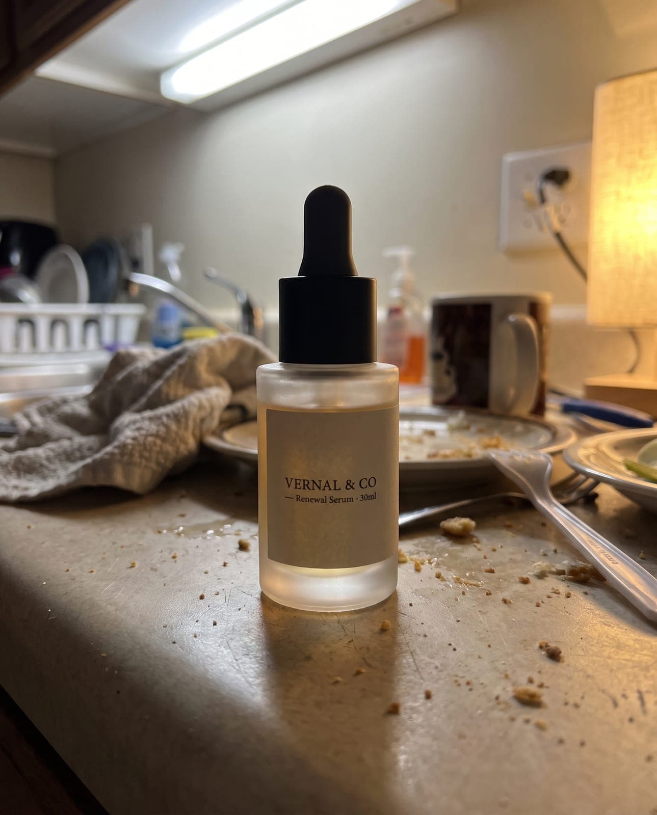 Amateur phone-style photo of a fictional skincare serum bottle (Vernal & Co Renewal Serum) on a cluttered counter, the before shot in a product photography comparison.